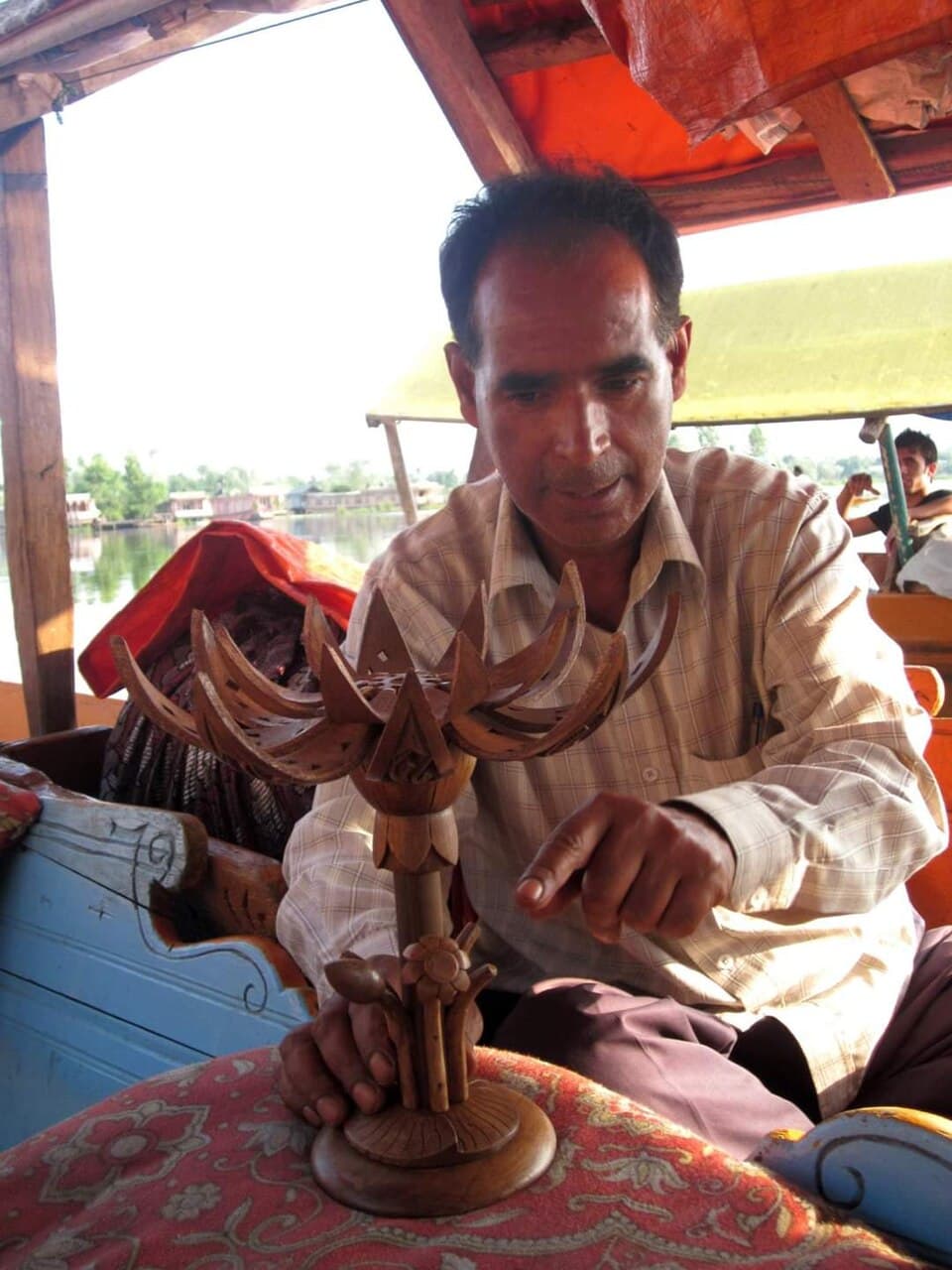 An artisan selling wood carvings from a shikara