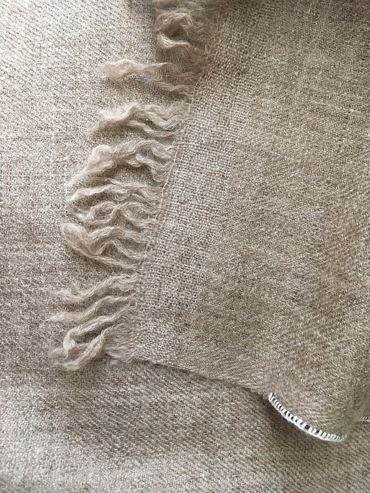 Hands at work on a handwoven pashmina shawl